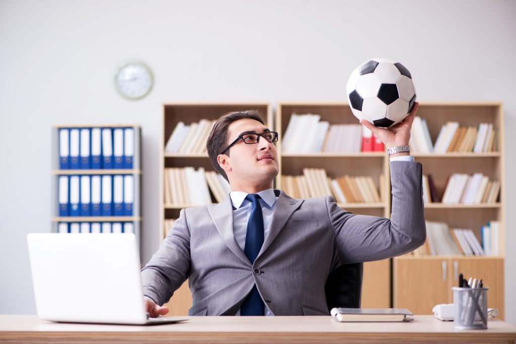 Businessman with football ball in office